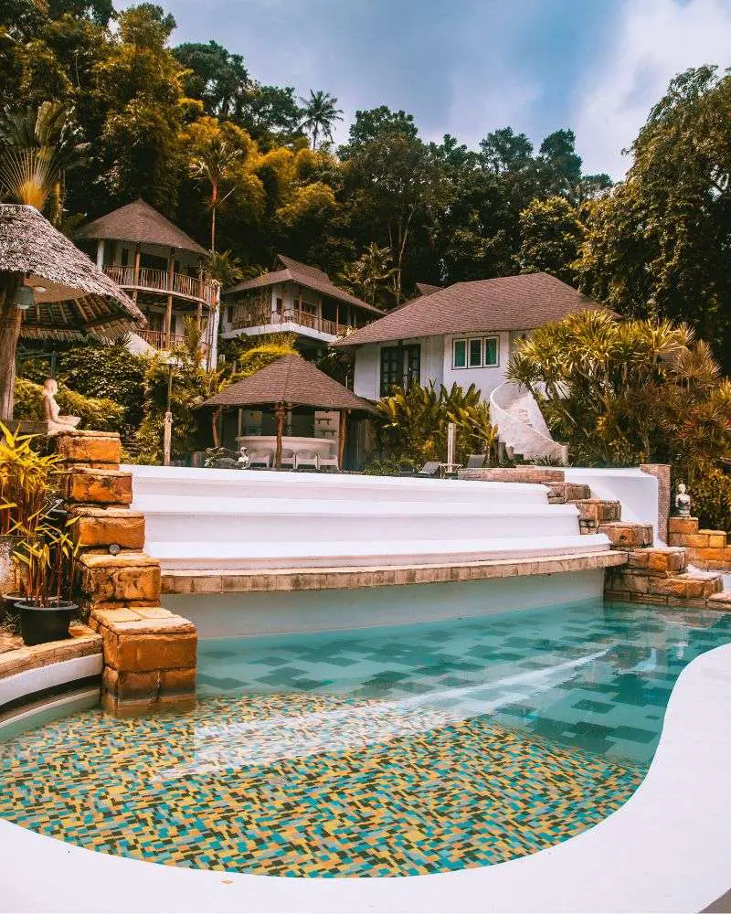 a pool with steps leading to a house in one of many over 50 singles resorts