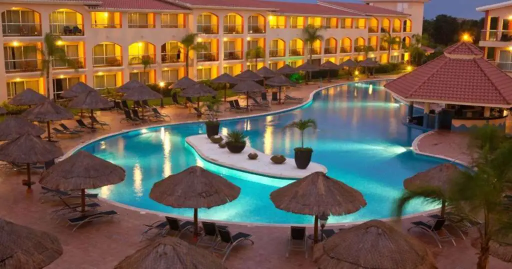 a pool with umbrellas and chairs in front of a building