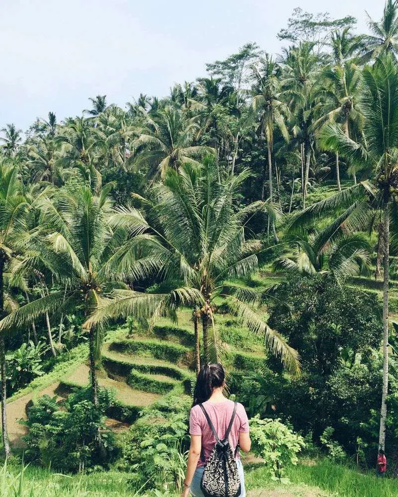 a woman standing in a jungle near one of many over 50 singles resorts