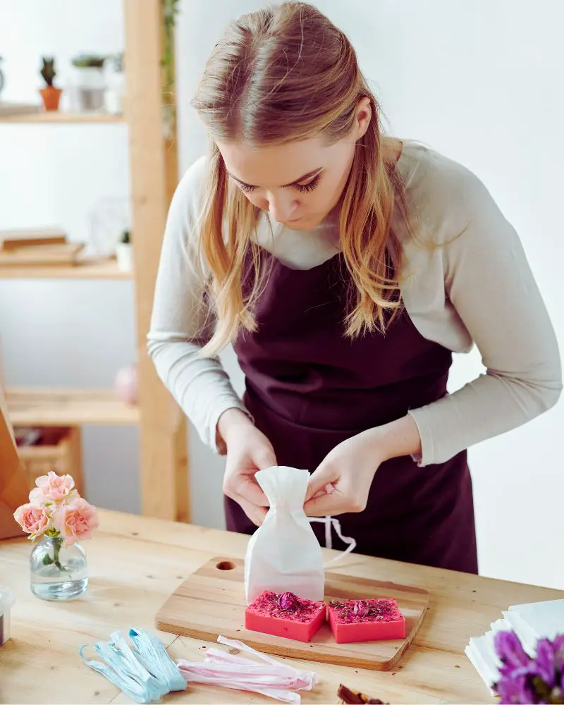 a woman opening a bag of soap after learning about selling handmade soap regulations