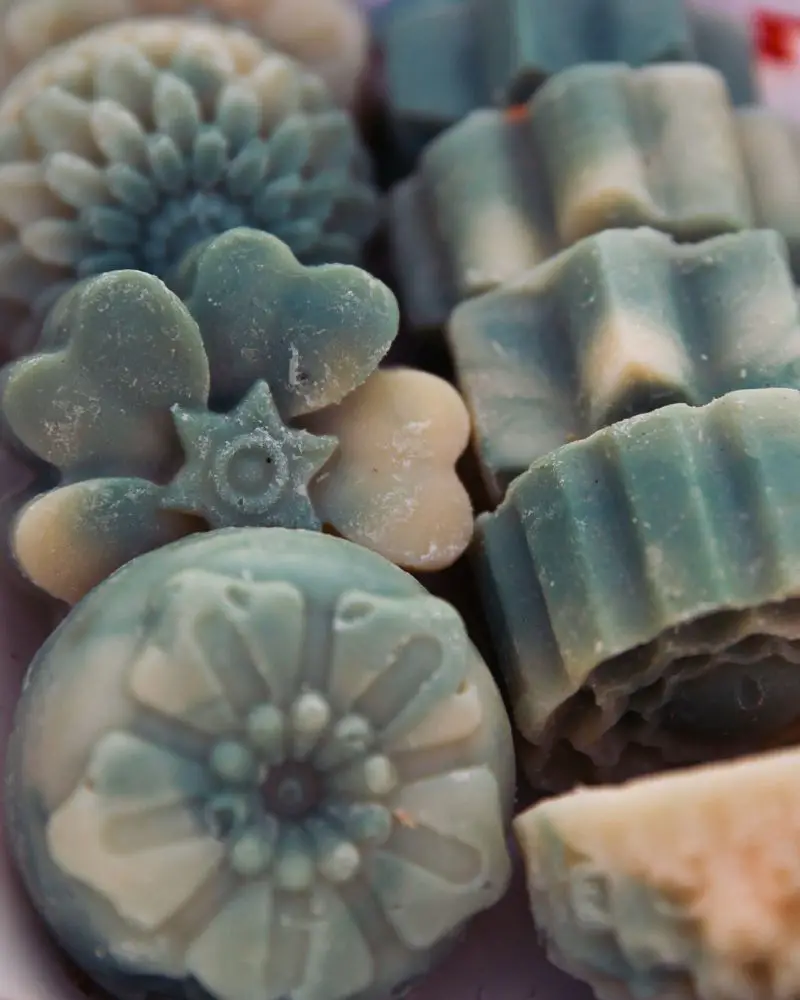 a group of green and white soaps made by someone aware of selling handmade soap regulations