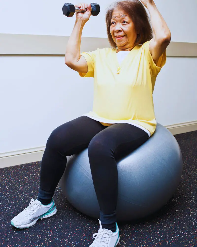 a woman sitting on a ball exercising and demonstrating that she shouldn't be lumped into the grannies over 60 category