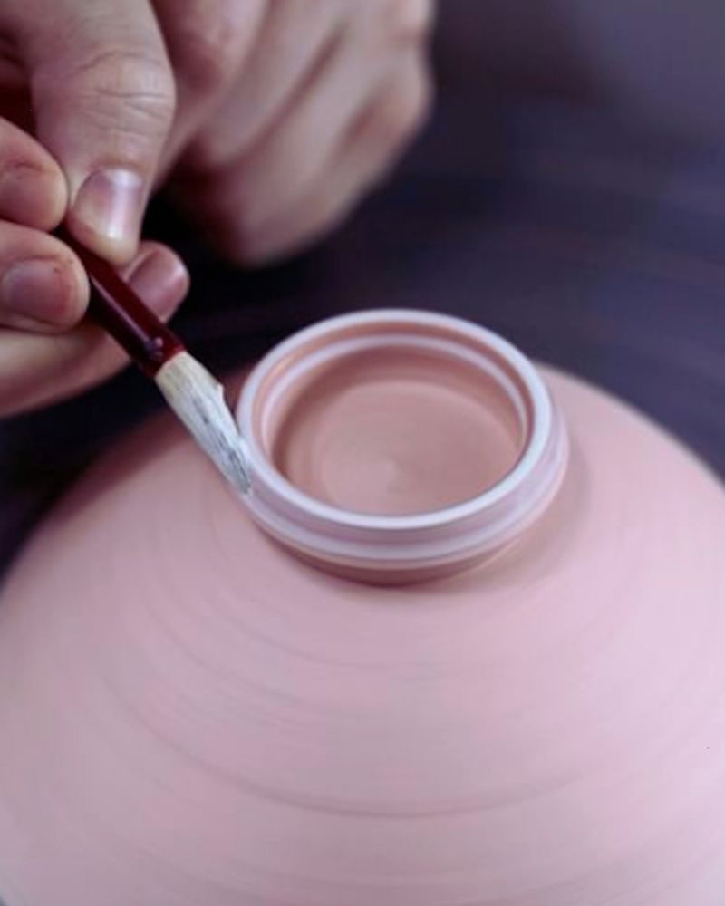 a person painting a clay pot after discovering a few cool pottery ideas