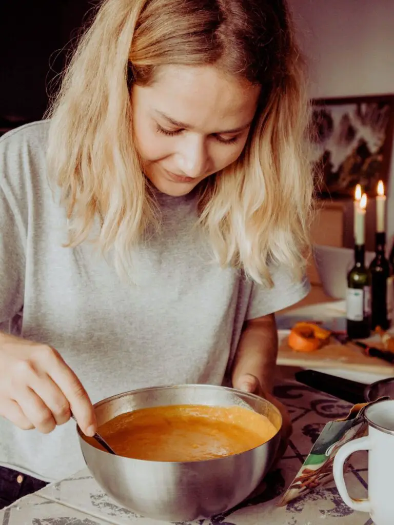 a woman holding a spoon in a pot with soup using a recipe generated with OpenAI tools