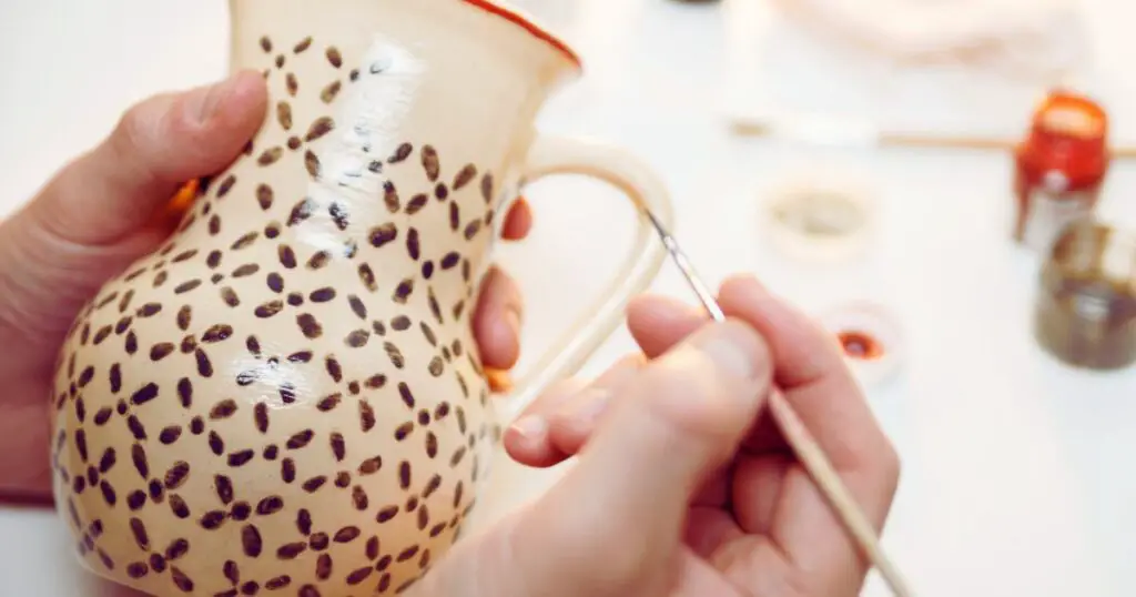 a person painting a vase after discovering cool pottery ideas