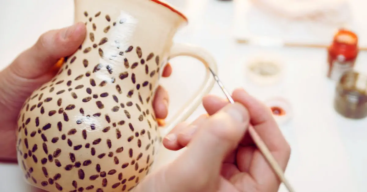 a person painting a vase after discovering cool pottery ideas