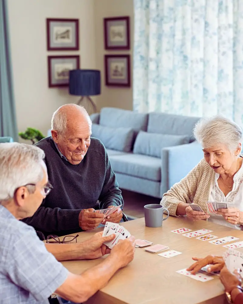 a group of people playing cards that shows there are many hobbies for people with mobility issues