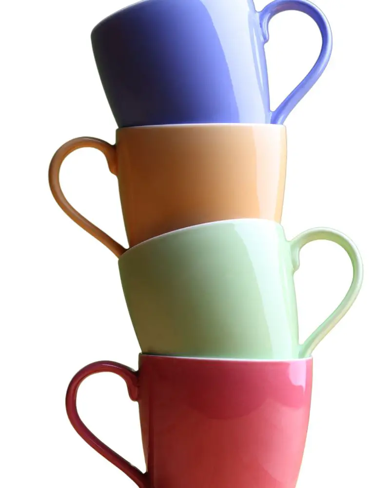 a stack of colorful coffee cups that make people ask, "Is pottery microwave safe?"