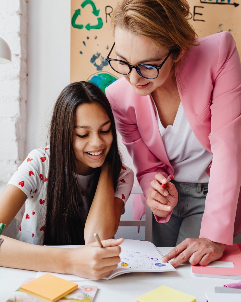 a woman and a girl looking at a piece of paper