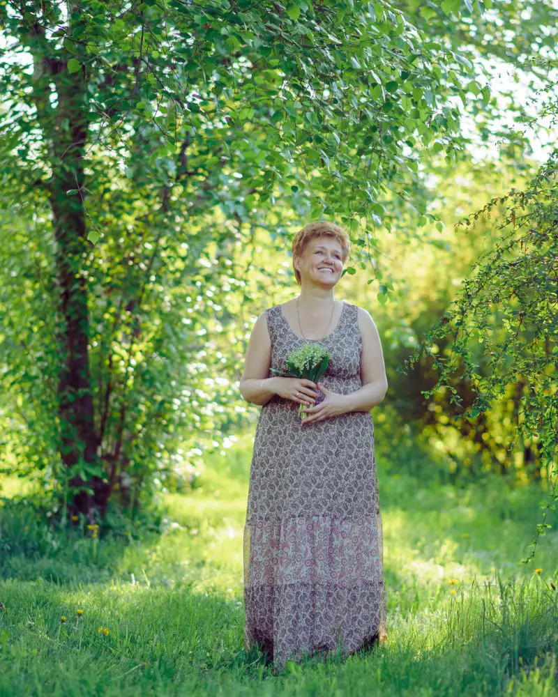 a woman in a dress holding a bouquet of flowers