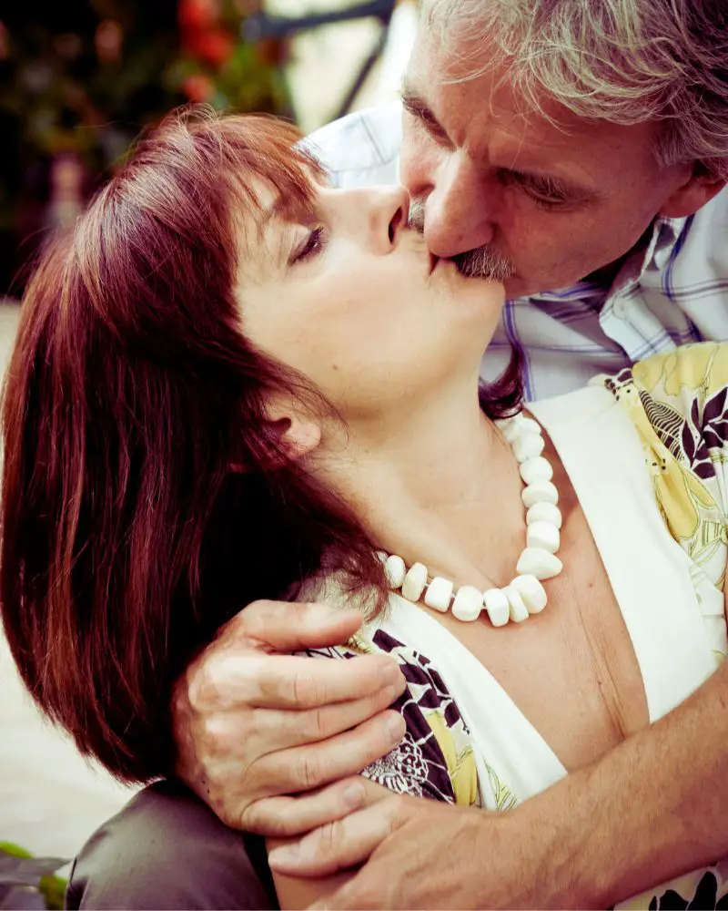 a woman kissing a man after deciding that dating a widower over 50 was worth it