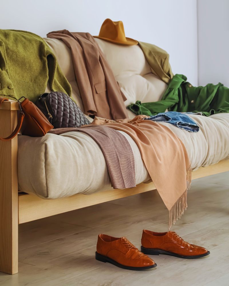 a couch with clothes and shoes