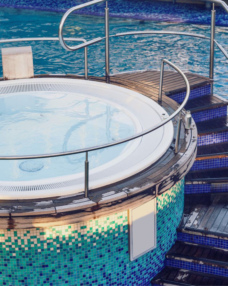 a jacuzzi with a railing on a pool