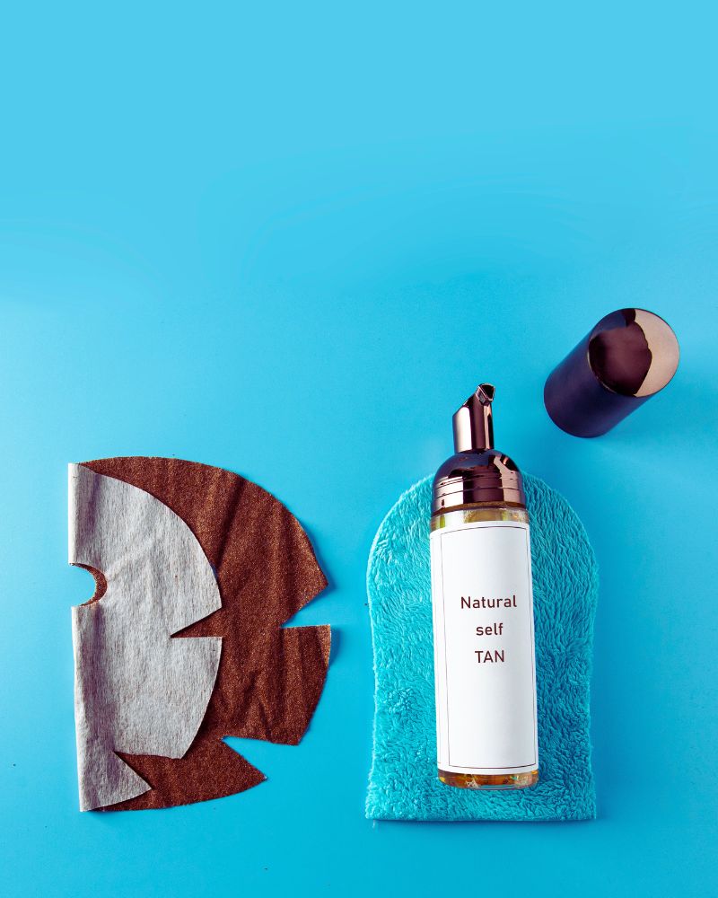 a tanning lotion bottle and a blue towel