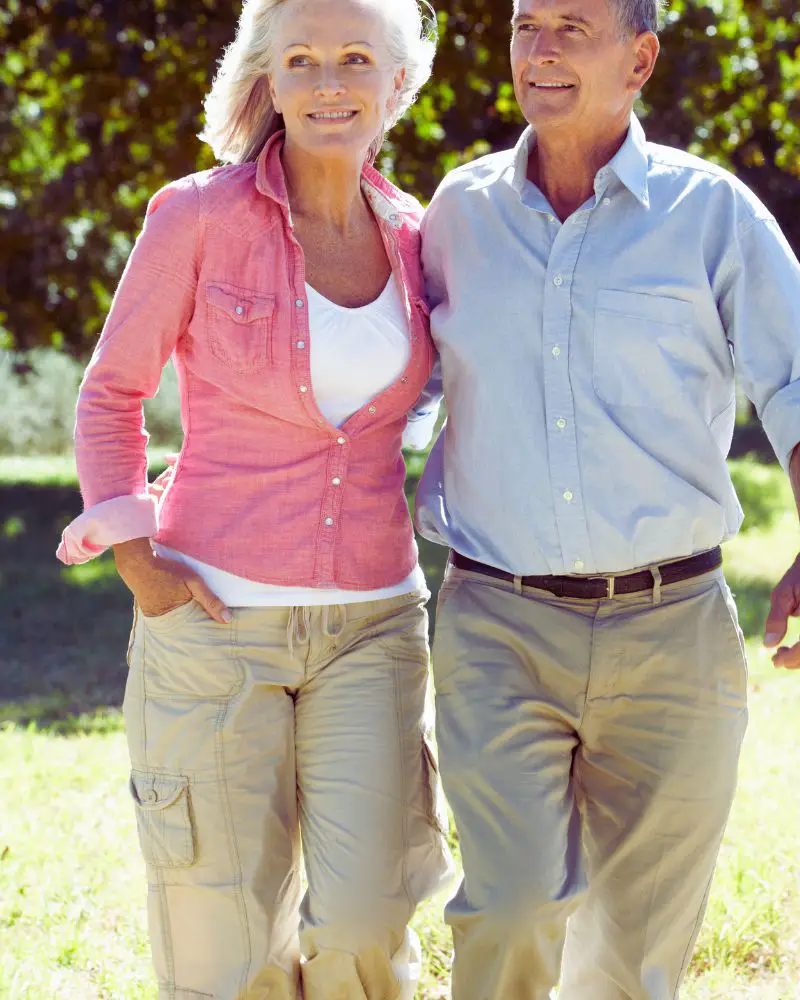 a man and woman walking in a park after understanding the ups and downs of dating a widower over 50