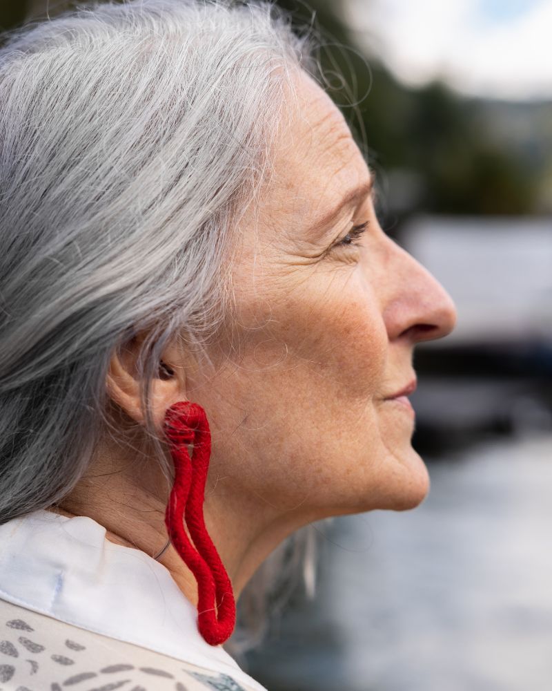 a woman with a red earring to demonstrate one of many options for ear piercing over 50