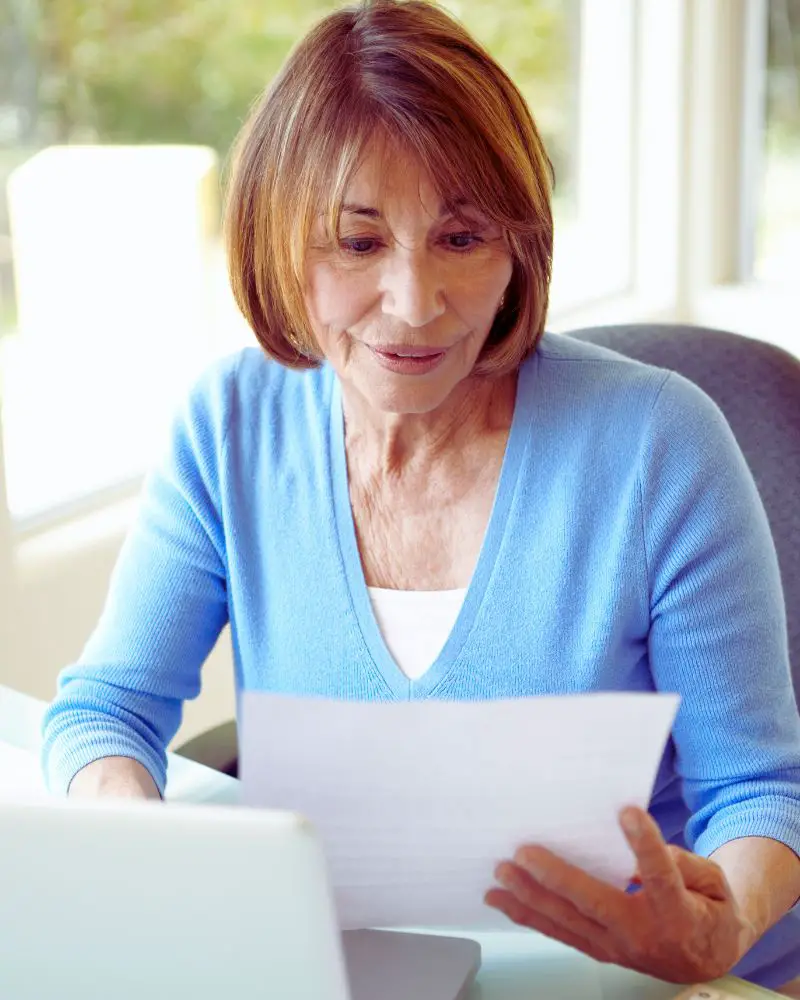 a woman looking at a piece of paper working on a side hustle and represents the many senior side hustle statistics