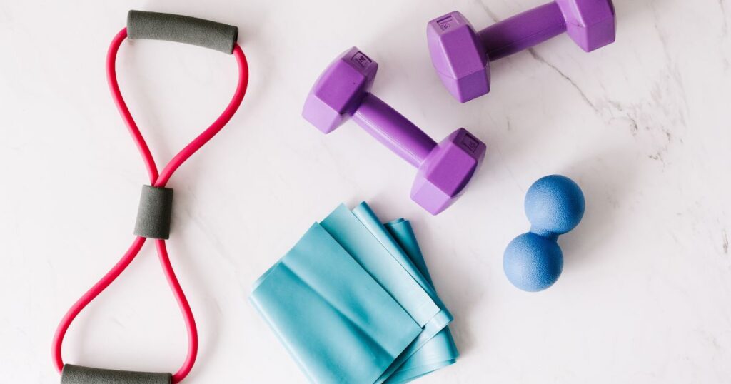 a purple dumbbells and a blue band to demonstrate the best exercise equipment for over 60