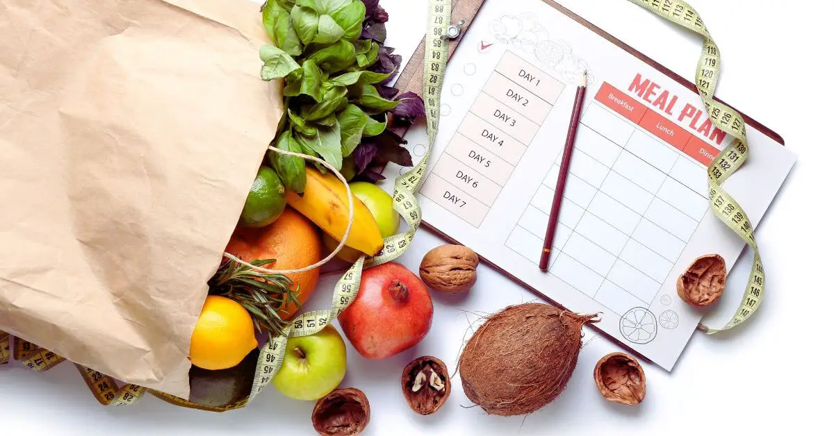 a paper bag full of fruits and vegetables next to a calendar