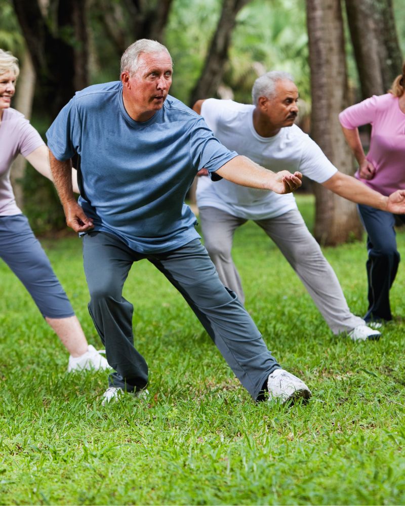 a group of people exercising in the grass and exploring the best martial arts for seniors