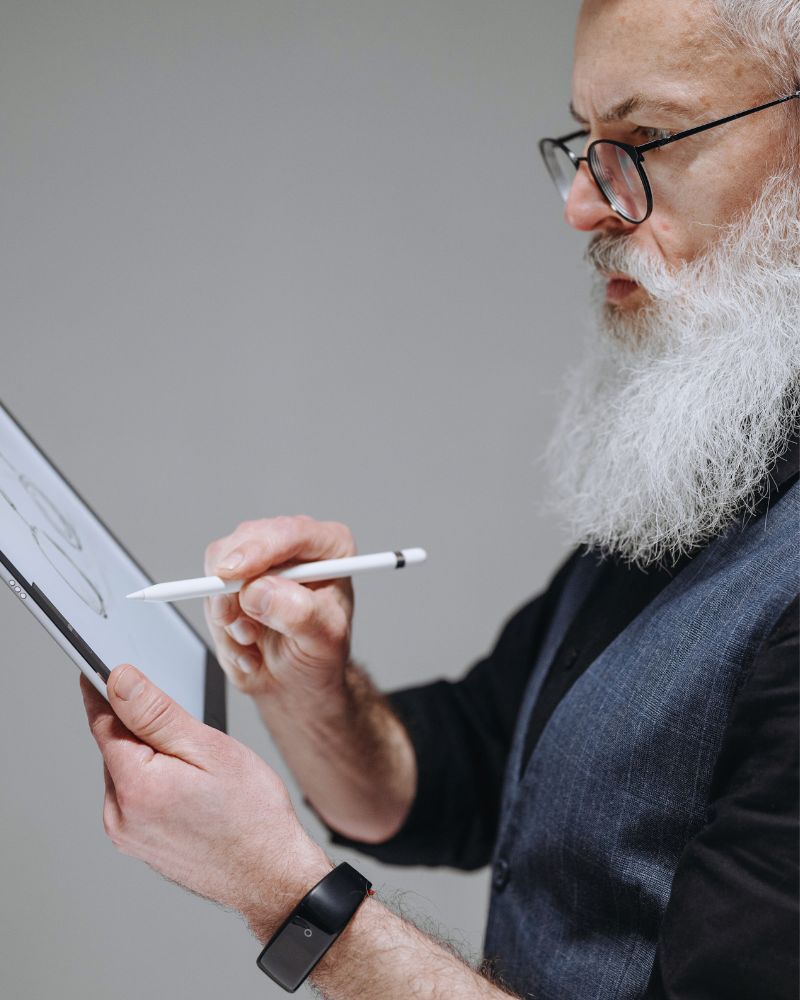 a man holding a pen and drawing on a tablet using a planner for writers