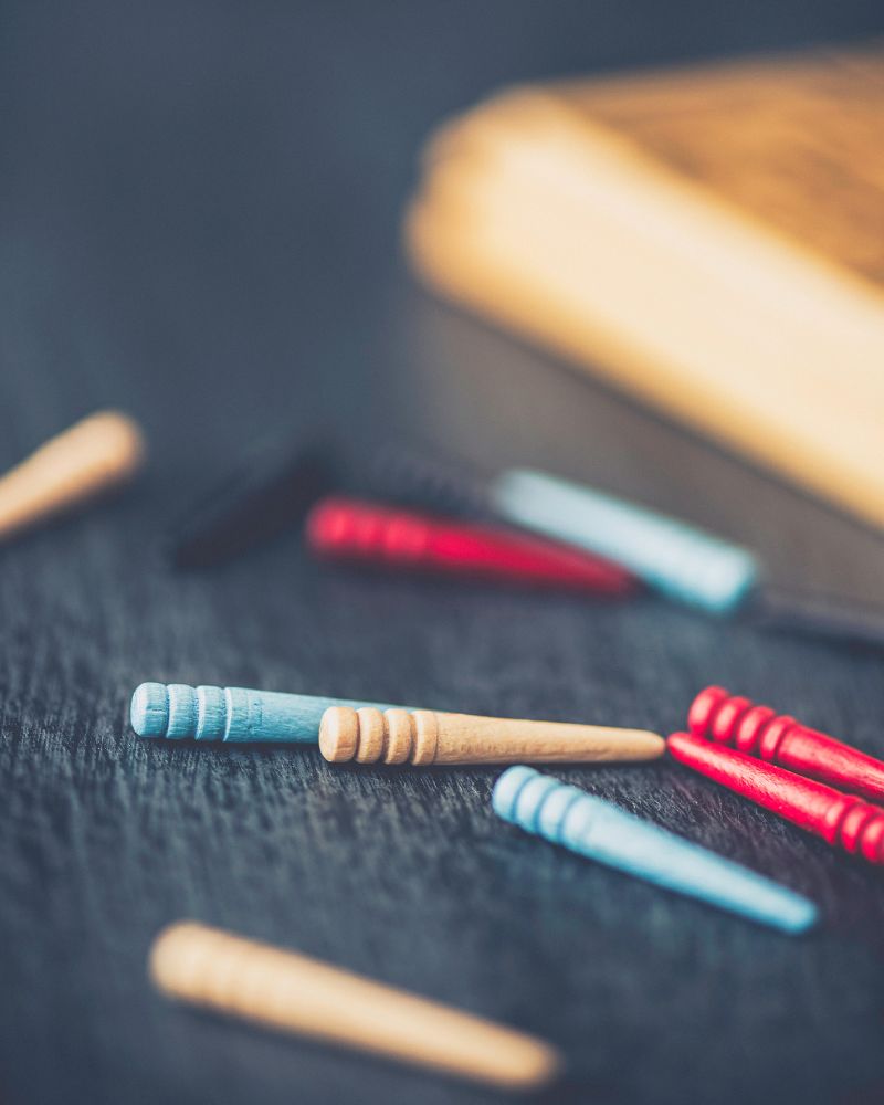 a group of wooden sticks on a table used for a cribbage board after creating one with a cribbage board printable template