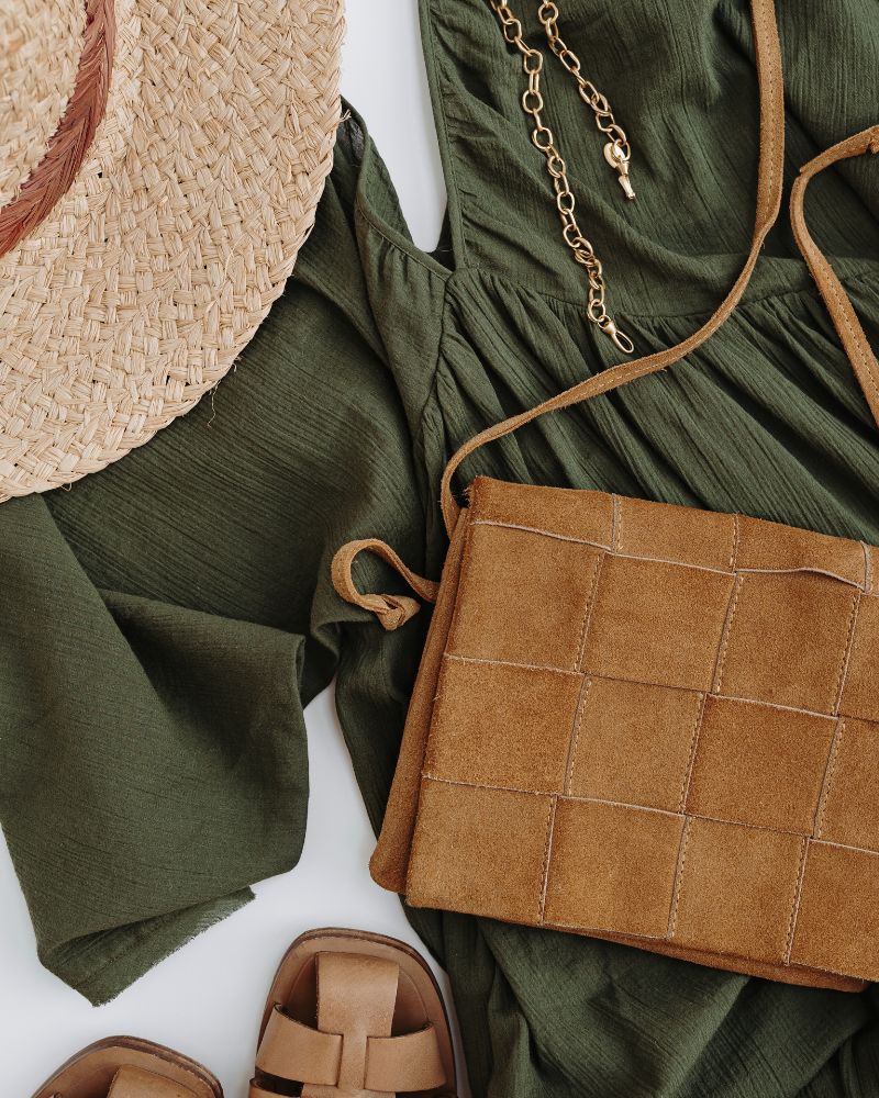 a green dress and a straw hat to demonstrate the boho style over 50 vibe