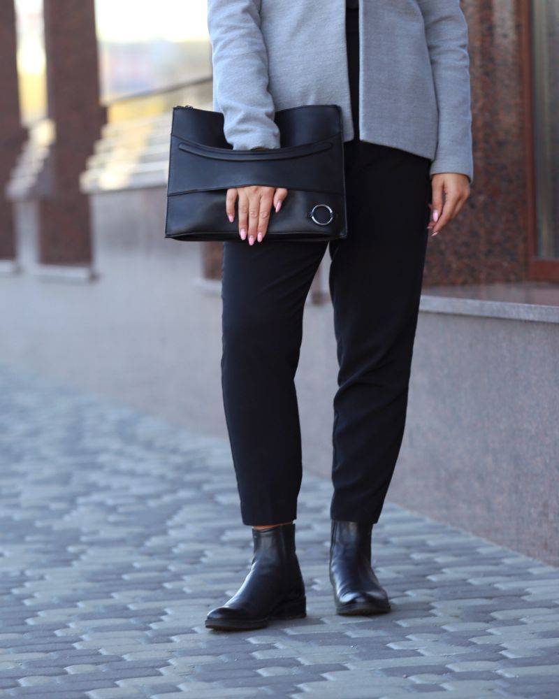 a woman holding a black purse and wearing leggings for women over 60