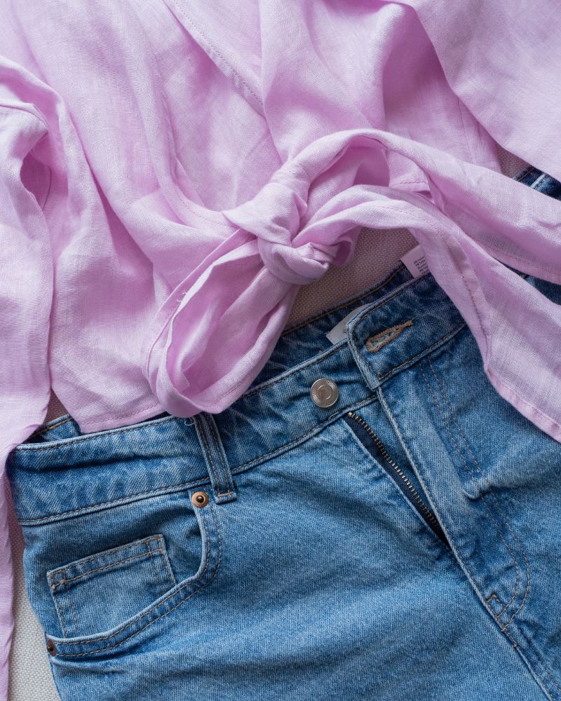 a pair of jeans with a pink scarf tied around the waist