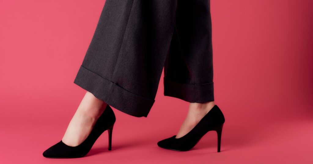 a pair of legs in black high heels image of a woman wearing wide leg pants over 50